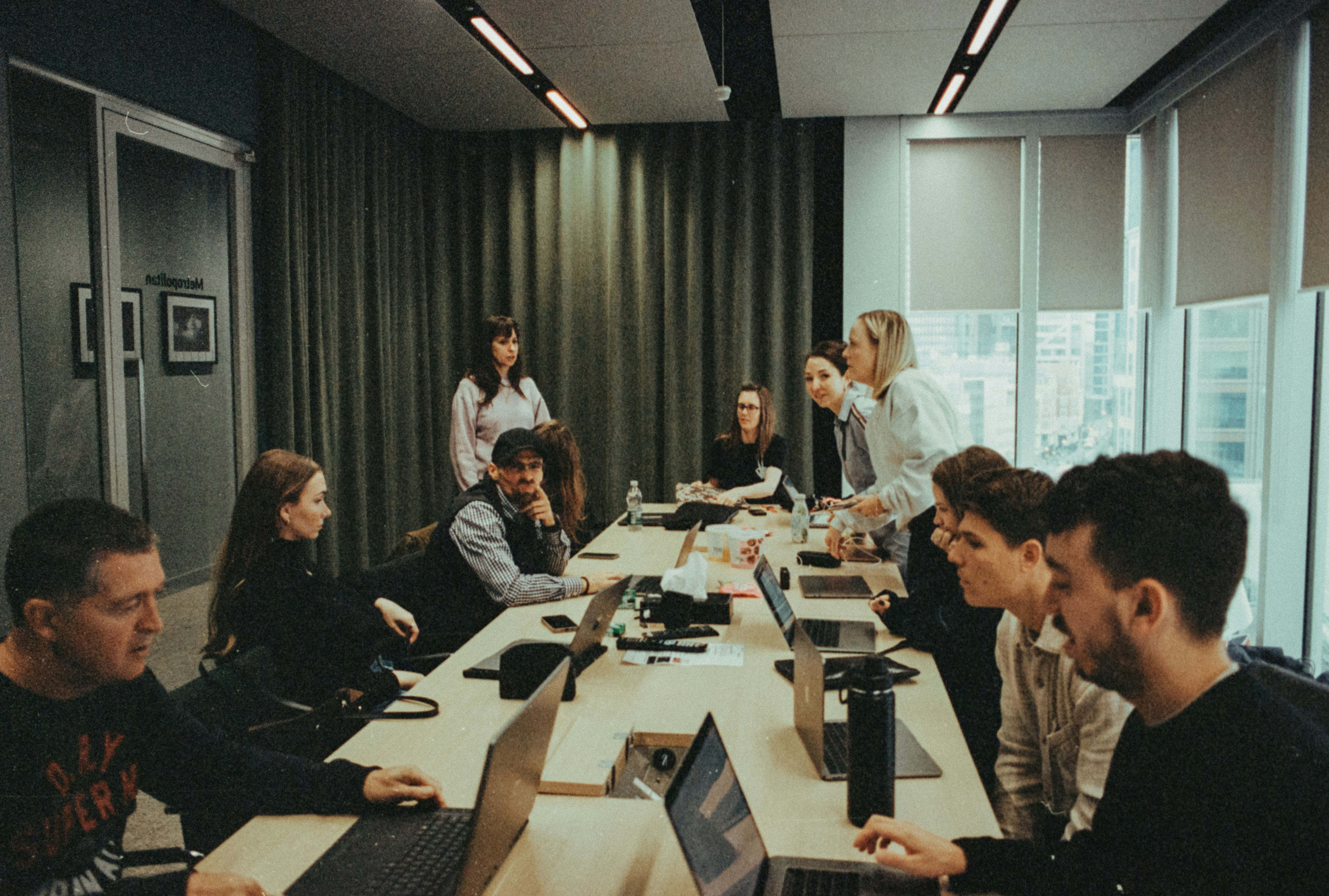 People collaborating at a long table with laptops